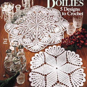 May include: A vintage image showcasing white crochet doilies with intricate designs, alongside glassware, a bunch of grapes, and decorative items. The text reads "Classic Doilies, 5 Designs to Crochet."