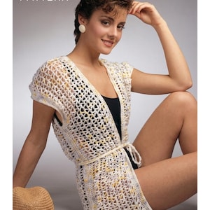 May include: A PDF pattern for a crochet vest. The vest is white with yellow accents and a tie belt. The text "PDF File PATTERN" is in the upper left corner. A straw hat is in the lower left corner.