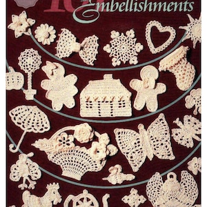 Op de afbeelding: Een verzameling draadgehaakte versieringen in diverse vormen, waaronder bloemen, strikken, sneeuwvlokken, een hart, een huis, een peperkoeken man, een paraplu, een mand, een vlinder, een theepot en een kruis. De tekst "101 Embellishments" staat bovenaan.