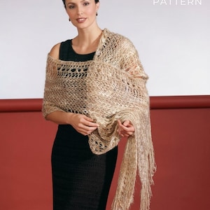 Può includere: Una donna indossa uno scialle beige a trama aperta con frange. Lo scialle è drappeggiato su un vestito nero. Il testo "PDF File PATTERN" è visibile nell'angolo in alto a destra.