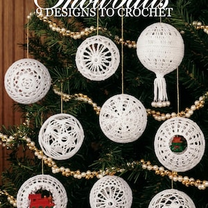 May include: Nine white crocheted ornaments with intricate lace patterns hanging from gold strings. The text at the top reads Snowballs 9 DESIGNS TO CROCHET. Some ornaments contain small red train or green gift decorations inside the openwork spheres.