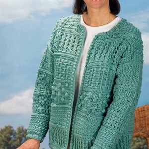 May include: A seafoam green long-sleeve cardigan featuring a variety of textured crochet patterns including bobbles, cables, and grid-like stitches. The garment has a round neckline, an open front design, and a straight hemline.