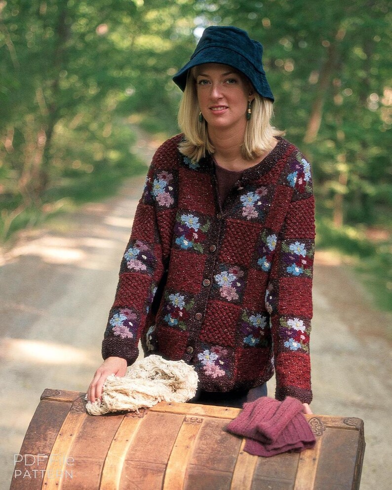 Puede incluir: Un sombrero de pescador azul oscuro y un c&aacute;rdigan de manga larga con botones frontales, con un dise&ntilde;o de patchwork de cuadrados texturizados de color rojo oscuro que se alternan con cuadrados de estampado floral multicolor en tonos azul, rosa y blanco.