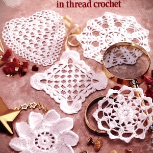 May include: A collection of white thread crochet doilies in various shapes, including a heart, a square, and a flower. The image also features a magnifying glass, a pocket watch, and the text "A Dozen Tiny Doilies in thread crochet."