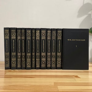 May include: A set of 15 black hardcover books with gold lettering. The books are titled "F.M. DOSTOEVSKY" and numbered 1 through 15.