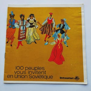 May include: A vintage travel poster with a mustard yellow background. It features illustrations of six women in traditional folk costumes. The text reads "100 peoples invite you to the Soviet Union" in French. The Intourist logo is in the bottom right corner.