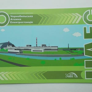 Könnte beinhalten: Eine grüne und blaue Postkarte mit einer stilisierten Illustration des Kernkraftwerks Tschernobyl. Das Bild zeigt die Gebäude des Kraftwerks, einen Fluss und den Text "Chornobylska Atomna Elektrostantsiia".