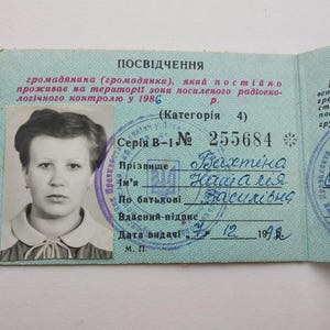 Könnte beinhalten: Ein ukrainischer Ausweis im Vintage-Stil mit einem Schwarz-Weiß-Porträt einer Frau. Das hellblaue Dokument enthält kyrillischen Text, Stempel und handschriftliche Details. Ausstellungsdatum: 7. Dezember 1992.