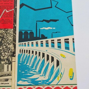 May include: A vintage book cover with a blue sky background and a stylized illustration of a dam with flowing water. The design includes yellow cars, industrial buildings, and a decorative border.