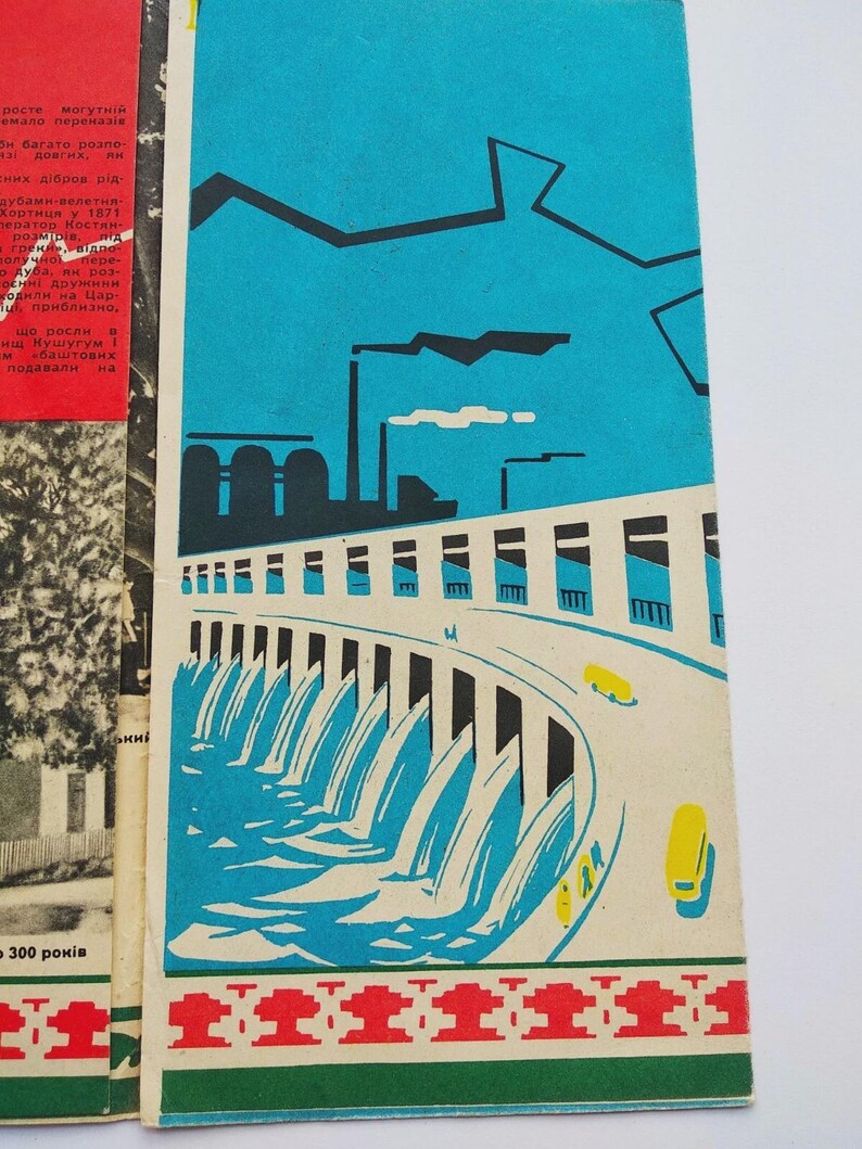 May include: A vintage book cover with a blue sky background and a stylized illustration of a dam with flowing water. The design includes yellow cars, industrial buildings, and a decorative border.