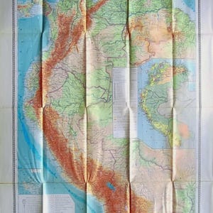 Peut inclure: Une carte pliée vintage représentant la Colombie, le Venezuela, l'Équateur, le Pérou et la Bolivie. La carte présente des détails topographiques en vert, marron et bleu, avec du texte en langue étrangère.
