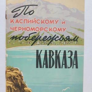 May include: Vintage travel poster with text in Russian, featuring a mountain range, sea, and coastline. The poster has a retro aesthetic with a color palette of beige, blue, and green. The word "KAVKAZA" is prominently displayed.