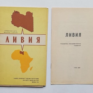 May include: Two vintage books. The cover of the first book is yellow with the word "LIBYA" in Russian. It features a map of Libya and Africa in brown and orange. The second book is off-white with the word "LIBYA" in Russian.