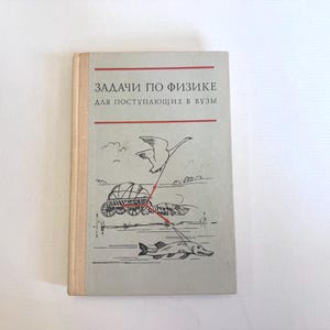 May include: A vintage book with a light grey cover featuring Russian text and illustrations. The title is in red, with a drawing of a swan, a fish, and a wagon. The book has a beige spine and appears to be in good condition.