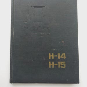 Może przedstawiać: Ciemnoszara książka z ilustracją maszyny na okładce. Książka zawiera złoty napis "H-14 H-15". Książka wygląda na katalog lub instrukcję.