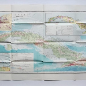 May include: Folded vintage map of Cuba, featuring detailed geographical information. The map displays the island with various colors indicating different regions and land features. The title "КУБА" is visible at the top.