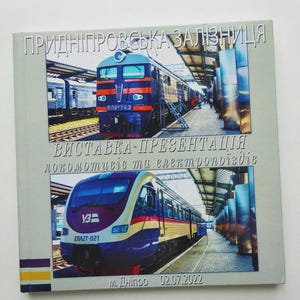 May include: A book cover featuring two train images. The top image shows a blue and red train at a station. The bottom image displays a purple, yellow, and red train. Ukrainian text is visible.