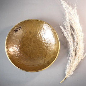 Peut inclure: Un bol en laiton martelé avec une surface texturée. Le bol porte une petite inscription sur le côté qui dit "HH III".