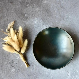 May include: A dark gray ceramic bowl with a smooth, rounded surface. The bowl is engraved with the text "Paul & Kerry".