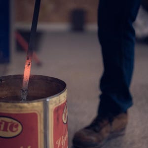 Pu&ograve; includere: Un'asta di metallo viene riscaldata in un contenitore di metallo rosso. Il contenitore ha un'etichetta rossa e bianca con la parola "HTC" su di essa.