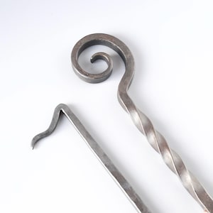Tisonnier en fer forgé à la main : outil de cheminée à volutes.