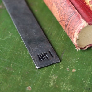 6 Tally Marks Stamped on the end of a Raw unpolished iron Bookmark