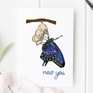 May include: A greeting card with a blue and purple butterfly emerging from a white cocoon. The card has the text "new you" written in blue.
