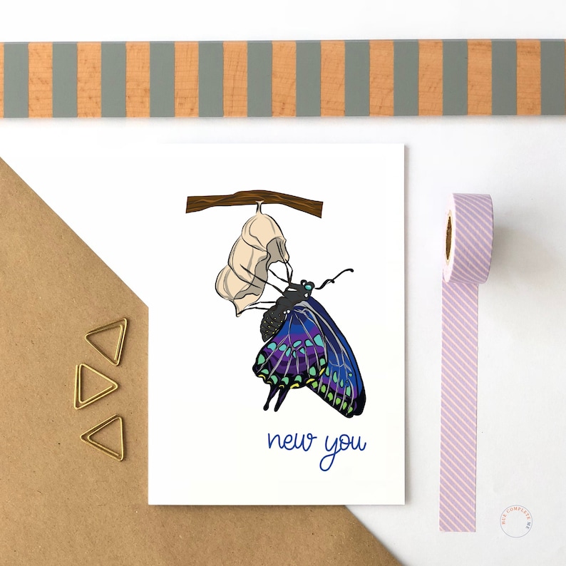 May include: A greeting card with a blue and purple butterfly emerging from a white cocoon. The card has the text "new you" in blue.