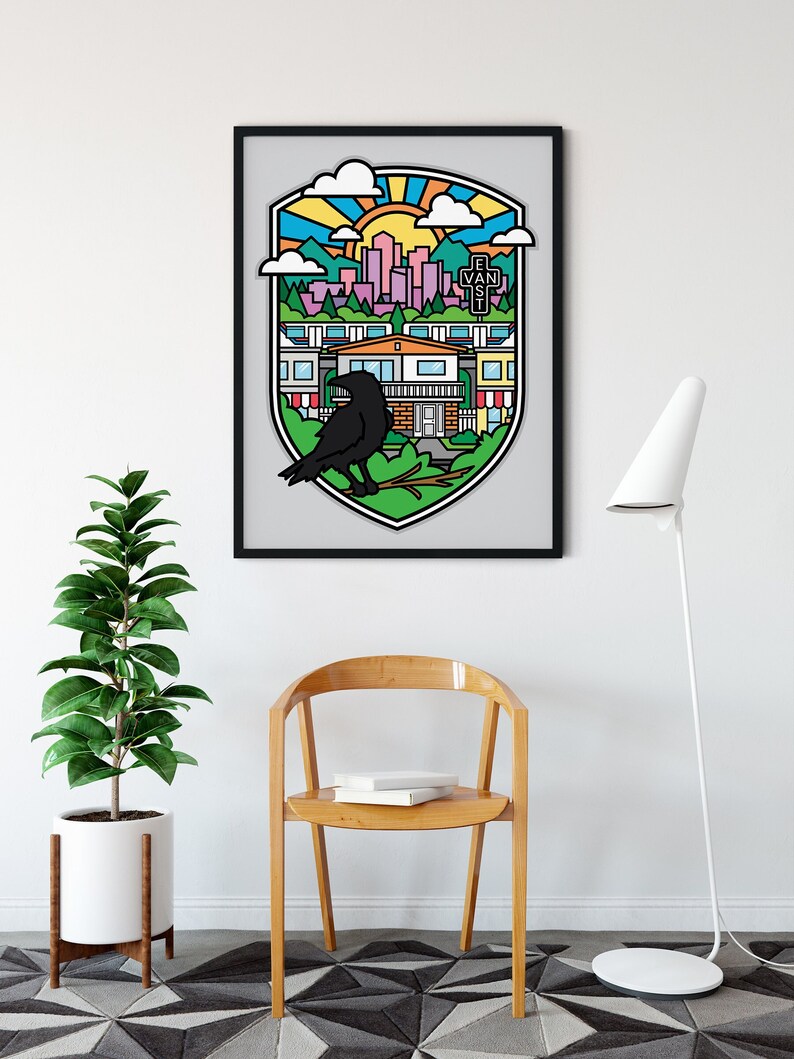 Op de afbeelding: Een zwart ingelijste print van een kleurrijke illustratie die een stadsbeeld met een kraai op een tak toont. De illustratie is in de stijl van een wapenschild of schild, met een zon, wolken en bergen op de achtergrond. De tekst "E. Van. St." is zichtbaar in de illustratie.