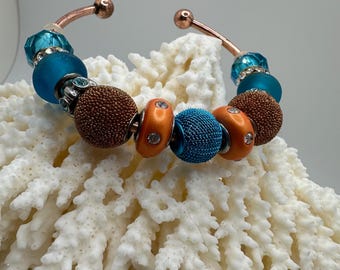 Rhinestones and Earthy Elegance: Copper Bangle with Orange and Teal Artisan Beads