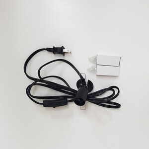 Pu&ograve; includere: Un cavo elettrico nero con una spina, un interruttore in linea e una presa. Sono incluse due lampadine trasparenti.
