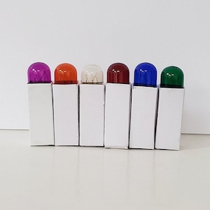 May include: Seven small light bulbs in clear glass packaging. The bulbs are colored purple, orange, white, red, blue, and green.