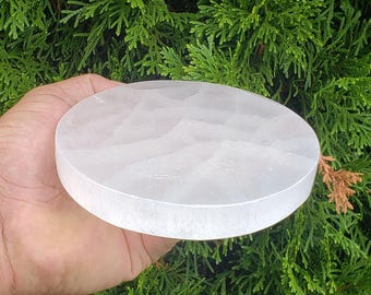 May include: A white selenite charging plate, a round disc of smooth, polished selenite crystal. The plate is approximately 6 inches in diameter.
