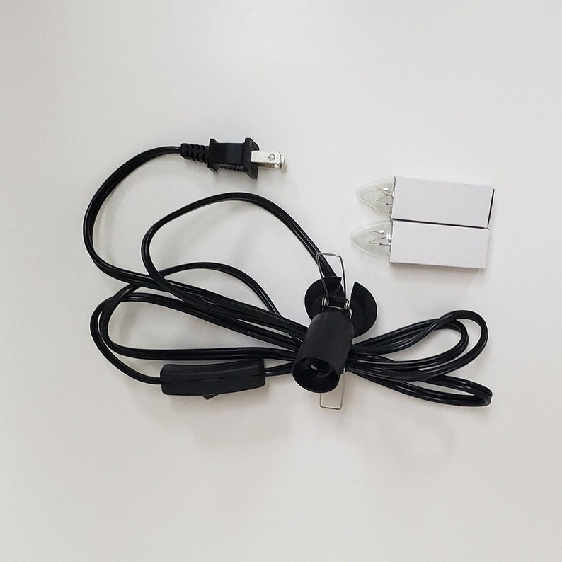 Pu&ograve; includere: Un cavo elettrico nero con una spina, un interruttore in linea e una presa per lampadina. Sono incluse due lampadine di ricambio.