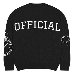 May include: Black crew neck sweatshirt with the word "OFFICIAL" in white block letters across the back. A white outline of a clock is on the left sleeve, and a white design is on the right sleeve.
