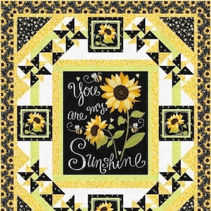 May include: A black and white quilt with a yellow border. The center of the quilt features a black panel with the text "You are my Sunshine" and a sunflower design. The quilt is made up of a repeating pattern of black and white triangles.