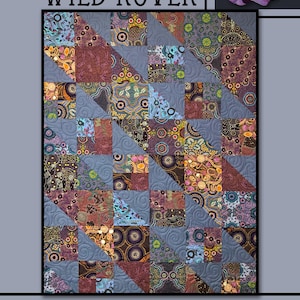 Może przedstawiać: Wzór kołdry o nazwie "Wild Rover" autorstwa Villa Rosa Designs. Kołdra wykonana jest z kolorowych kwadratów tkaniny z geometrycznym wzorem. Kołdra jest otoczona obramowaniem z fioletowych kwiatów i zielonych liści.