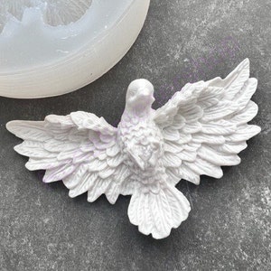 May include: A white dove with detailed wings and a textured surface. The dove is in a flying pose with its wings spread out.