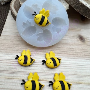 May include: Silicone mold with five bee shapes, and four yellow and black bee figurines.