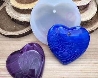 May include: Two heart-shaped resin pendants, one purple with white swirls and one blue with white swirls. Both pendants have a hole at the top for hanging.