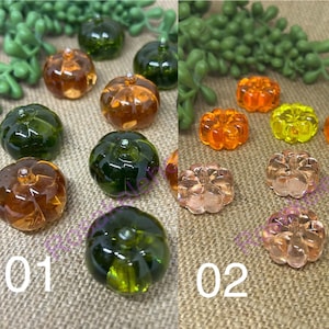 May include: Two sets of glass pumpkin beads in various colors, including green, orange, and yellow. The beads are arranged on a brown burlap surface. The first set is labeled "01" and the second set is labeled "02".