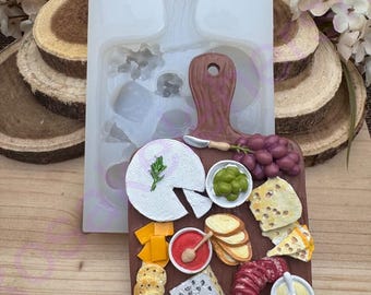 May include: A silicone mold for making a decorative charcuterie board with cheese, crackers, grapes, olives, salami, and honey. The mold is brown and has a wooden texture.