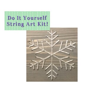 May include: A white string art snowflake design on a wooden background. The text "Do It Yourself String Art Kit!" is displayed above the image.