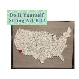 May include: A string art kit featuring a white string outline of the United States map on a wood background. A red heart is placed over the state of California.