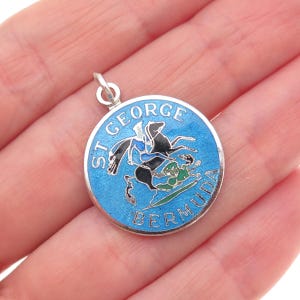 May include: A white ceramic mug with a black handle and the text "But First, Coffee" in a bold, black font. The mug is set against a blurred background, highlighting its clean design.