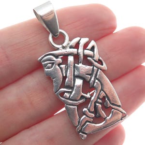 May include: Silver Celtic knot pendant with a detailed design. The pendant is in the shape of a knot with a Celtic design.