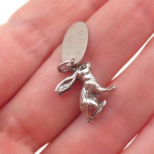 May include: A white ceramic mug with a black handle and the text "But First, Coffee" in a bold, black font. The mug is set against a blurred background, suggesting a cozy setting. The mug appears to be approximately 4 inches tall.