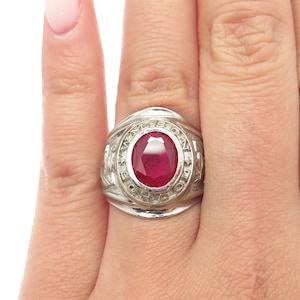 May include: A silver class ring with a red oval gemstone and the inscription "Marlston School Ohio 1970".