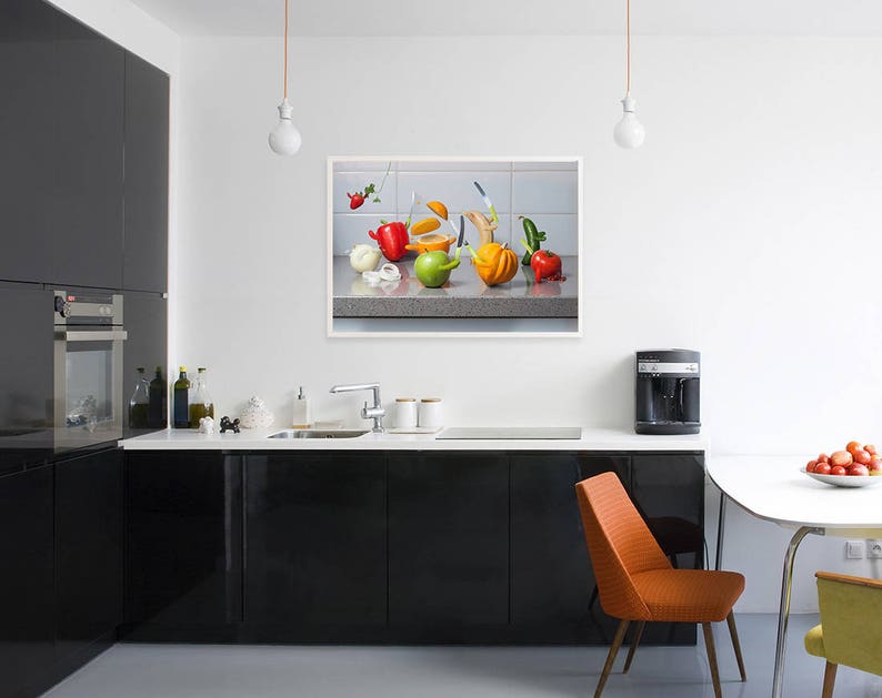 May include: A still life photograph of a kitchen counter with a variety of colorful fruits and vegetables arranged in a bowl. The fruits and vegetables include oranges, lemons, limes, apples, pears, and grapes. The bowl is made of ceramic and has a white glaze.