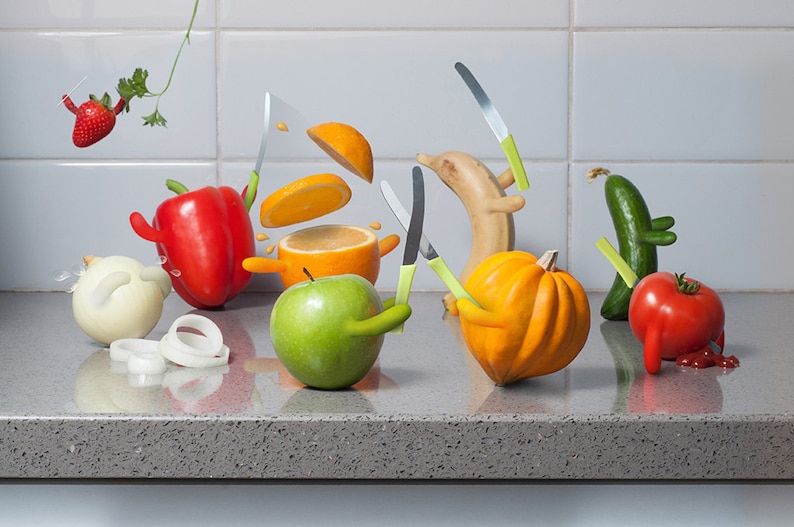May include: A humorous still life featuring various fruits and vegetables with knives stuck in them. The scene includes a red bell pepper, a green apple, a yellow squash, a green cucumber, a red tomato, a banana, an orange, and a white onion.